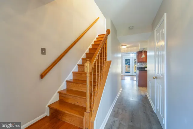 a view of a hallway with wooden floor and staircase
