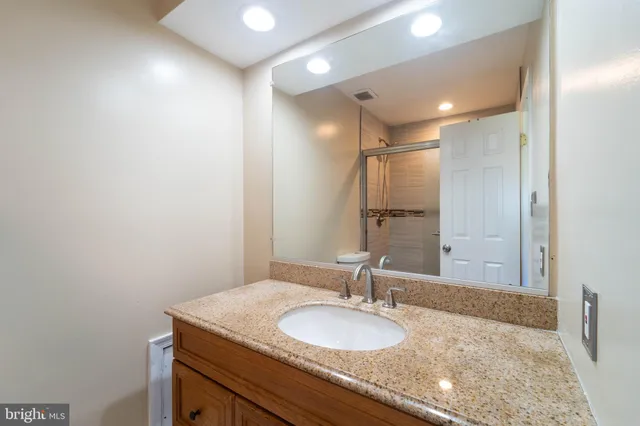 a bathroom with a granite countertop sink a mirror and a vanity