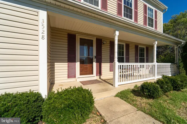 a view of a house with a small yard and wooden fence
