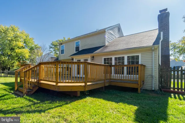 a view of a house with a wooden deck and a yard