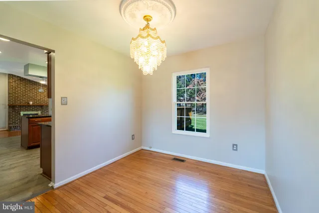 a view of a room with wooden floor and chandelier