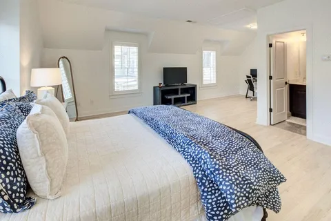 a bedroom with a bed and a chair in it