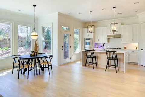 a view of a dining room and livingroom with furniture wooden floor a chandelier