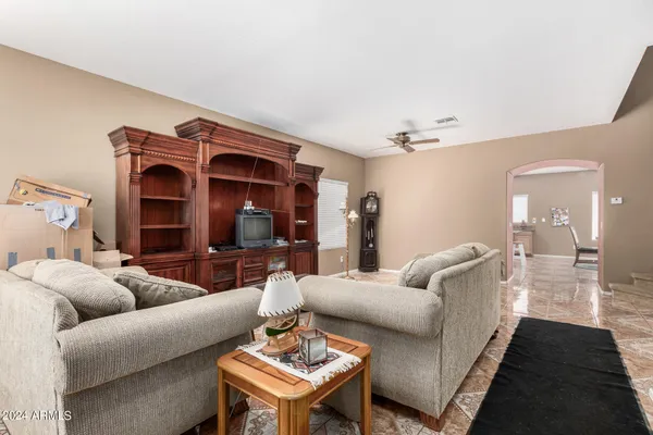 a living room with furniture a ceiling fan and a rug
