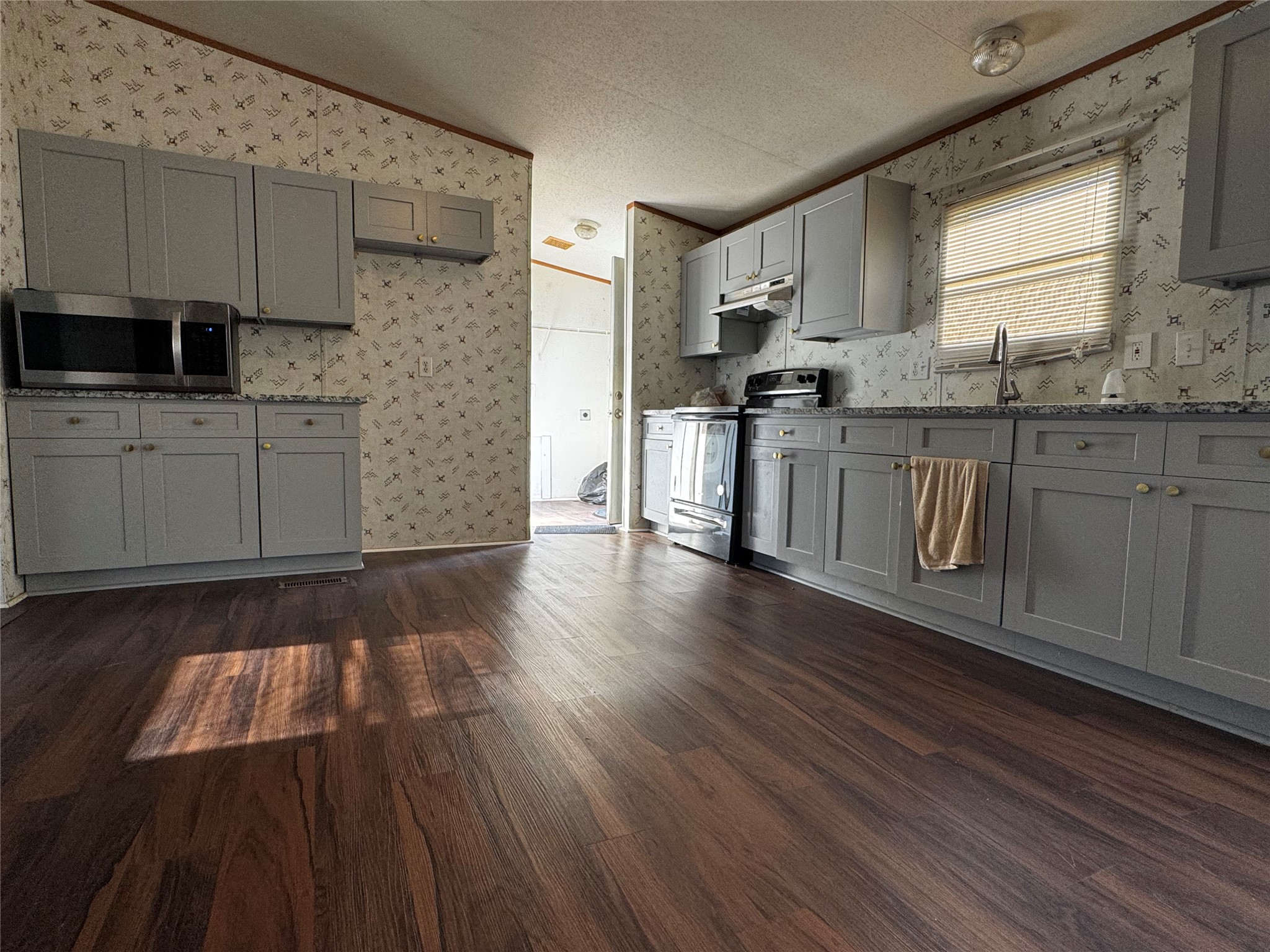 15930 Boss Gaston Road Sugar Land, TX 77498 - Photo 7 of 20 a kitchen with granite countertop wooden floors a sink and cabinets