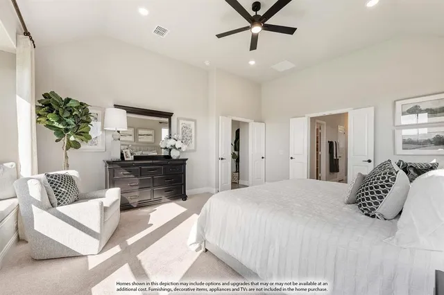 a bedroom with a bed a couch and potted plant on the dresser