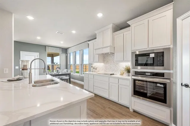 a kitchen with kitchen island a stove a sink and a microwave