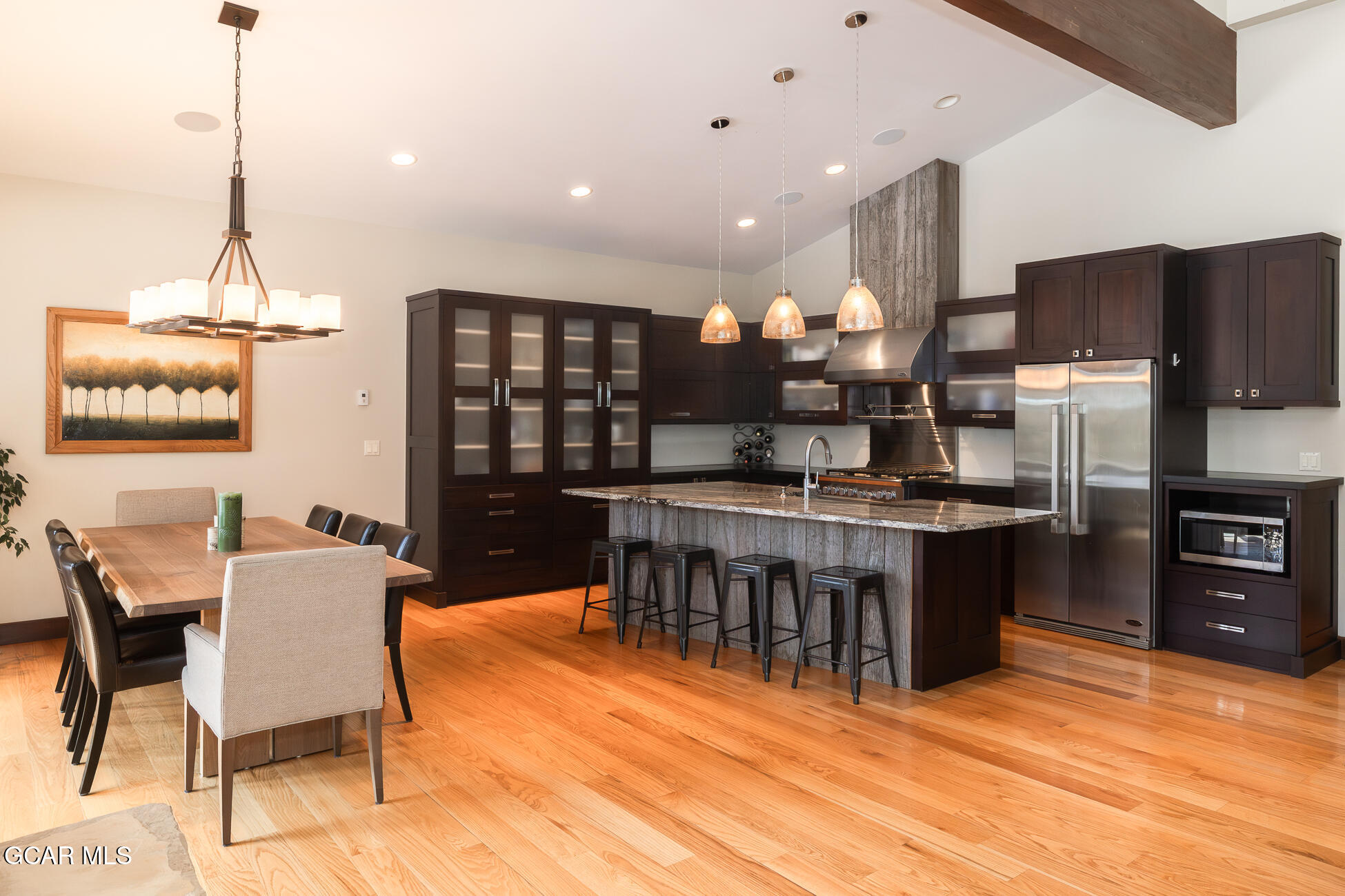 492 Mountain Peak Road Tabernash, CO 80478 - Photo 19 of 29 a kitchen with stainless steel appliances kitchen island granite countertop a table chairs in it and wooden floors