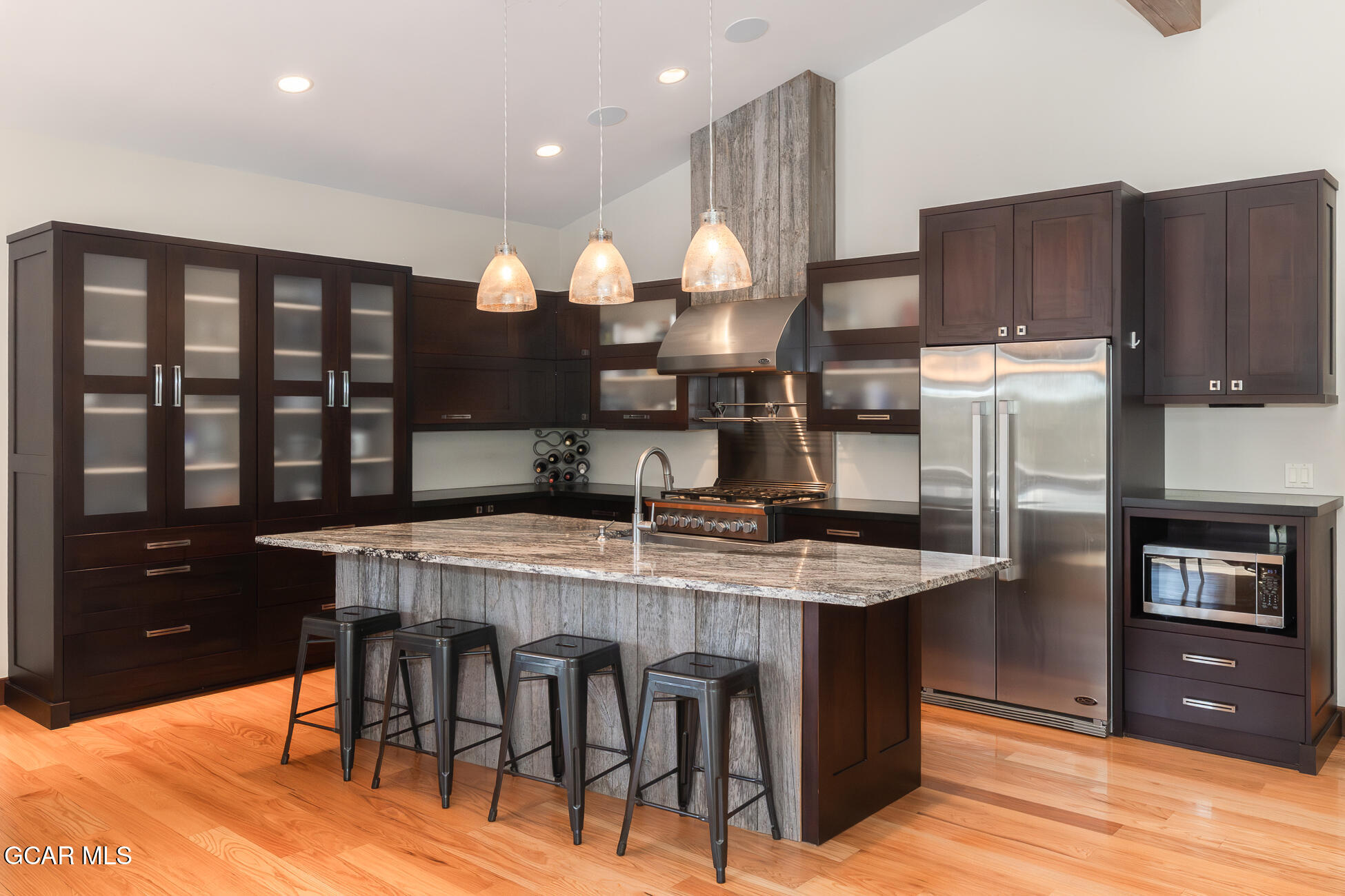 492 Mountain Peak Road Tabernash, CO 80478 - Photo 4 of 29 a kitchen with stainless steel appliances granite countertop a stove a refrigerator a sink a dining table and chairs with wooden floor