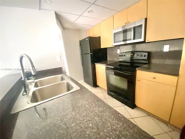 a kitchen with stainless steel appliances granite countertop a sink and a stove