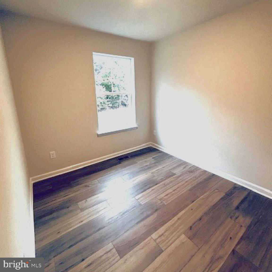719 R Wilson Loop Georgetown, DE 19947 - Photo 6 of 17 an empty room with wooden floor and window