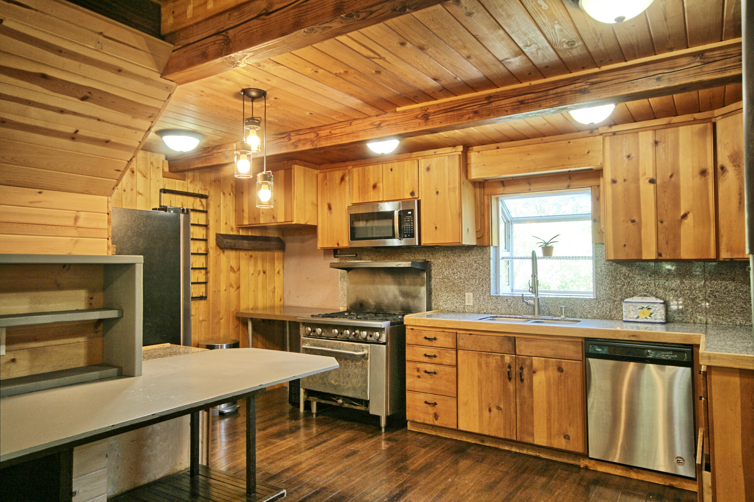 2231 Humbug Creek Road Jacksonville, OR 97530 - Photo 22 of 80 a kitchen with kitchen island a stove a sink and a refrigerator