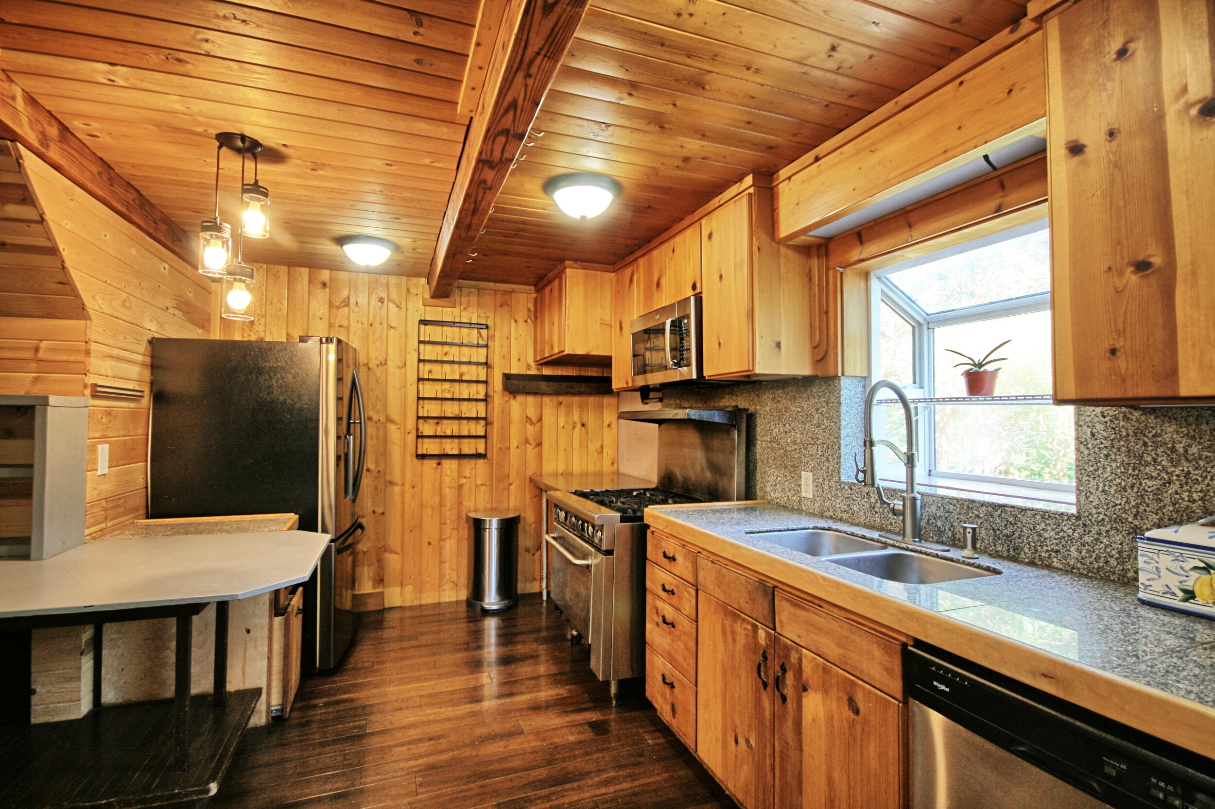 2231 Humbug Creek Road Jacksonville, OR 97530 - Photo 24 of 80 a kitchen with stainless steel appliances granite countertop a sink a stove and a wooden floors