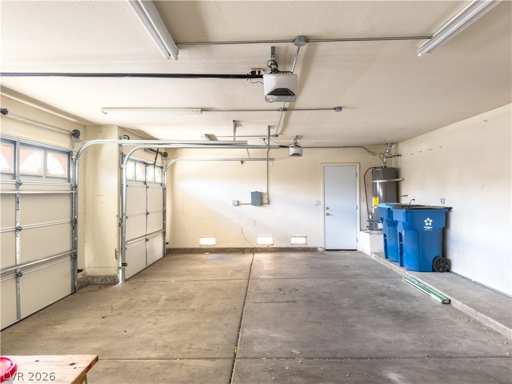 1842 Bogey Way Henderson, NV 89074 - Photo 13 of 25 Garage featuring strapped water heater and a garage door opener