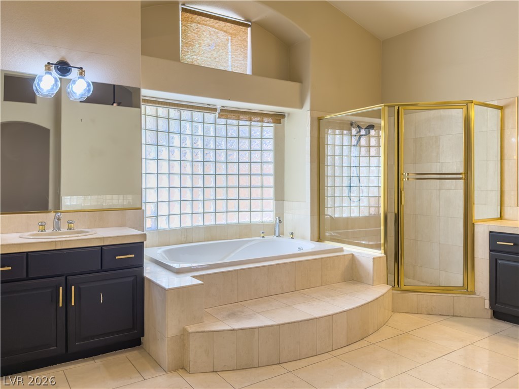 1842 Bogey Way Henderson, NV 89074 - Photo 16 of 25 Bathroom with vanity, a stall shower, a bath, and light tile patterned floors