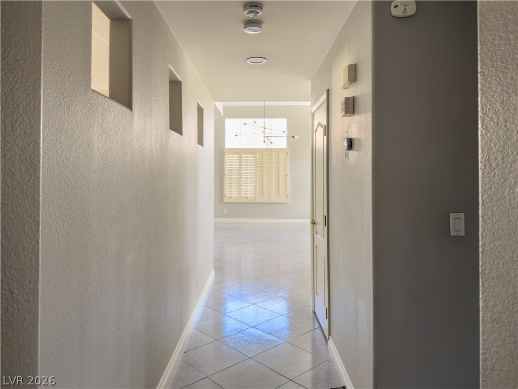 1842 Bogey Way Henderson, NV 89074 - Photo 19 of 25 Corridor with light tile patterned floors and a textured wall