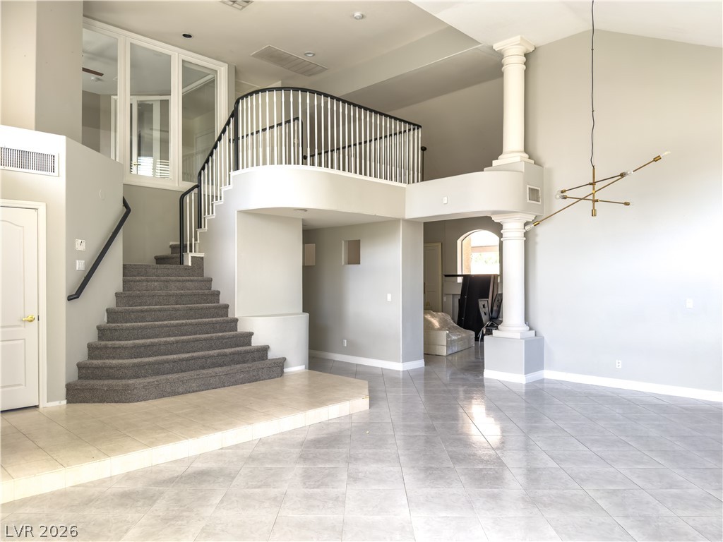 1842 Bogey Way Henderson, NV 89074 - Photo 3 of 25 Stairway with a high ceiling, decorative columns, and tile patterned floors
