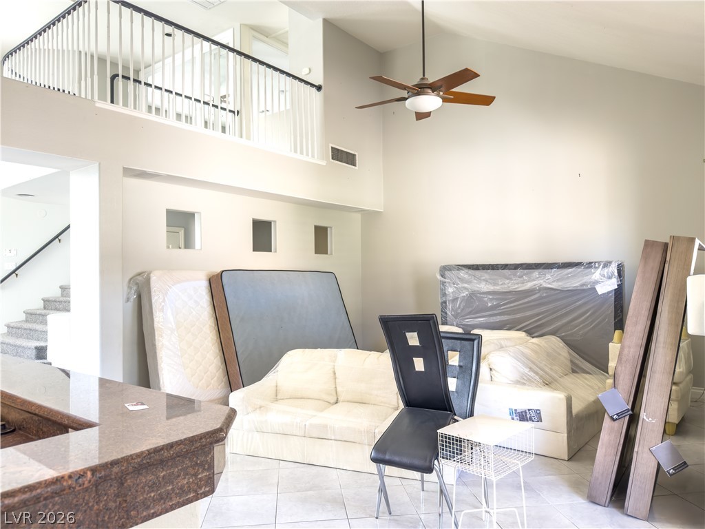 1842 Bogey Way Henderson, NV 89074 - Photo 7 of 25 Tiled living room with a ceiling fan and vaulted ceiling