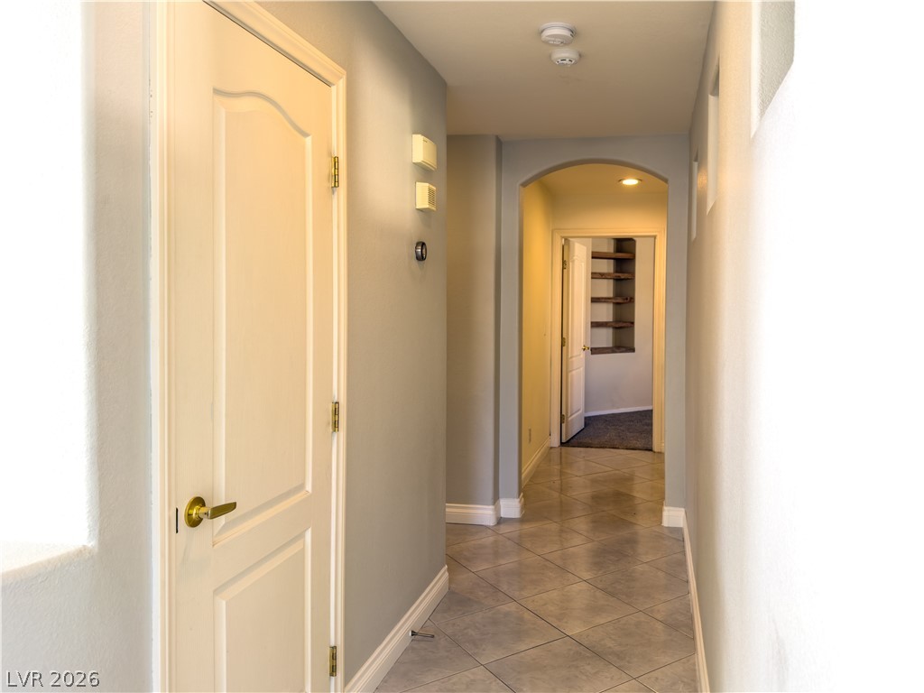 1842 Bogey Way Henderson, NV 89074 - Photo 10 of 25 Hallway with arched walkways and light tile patterned floors