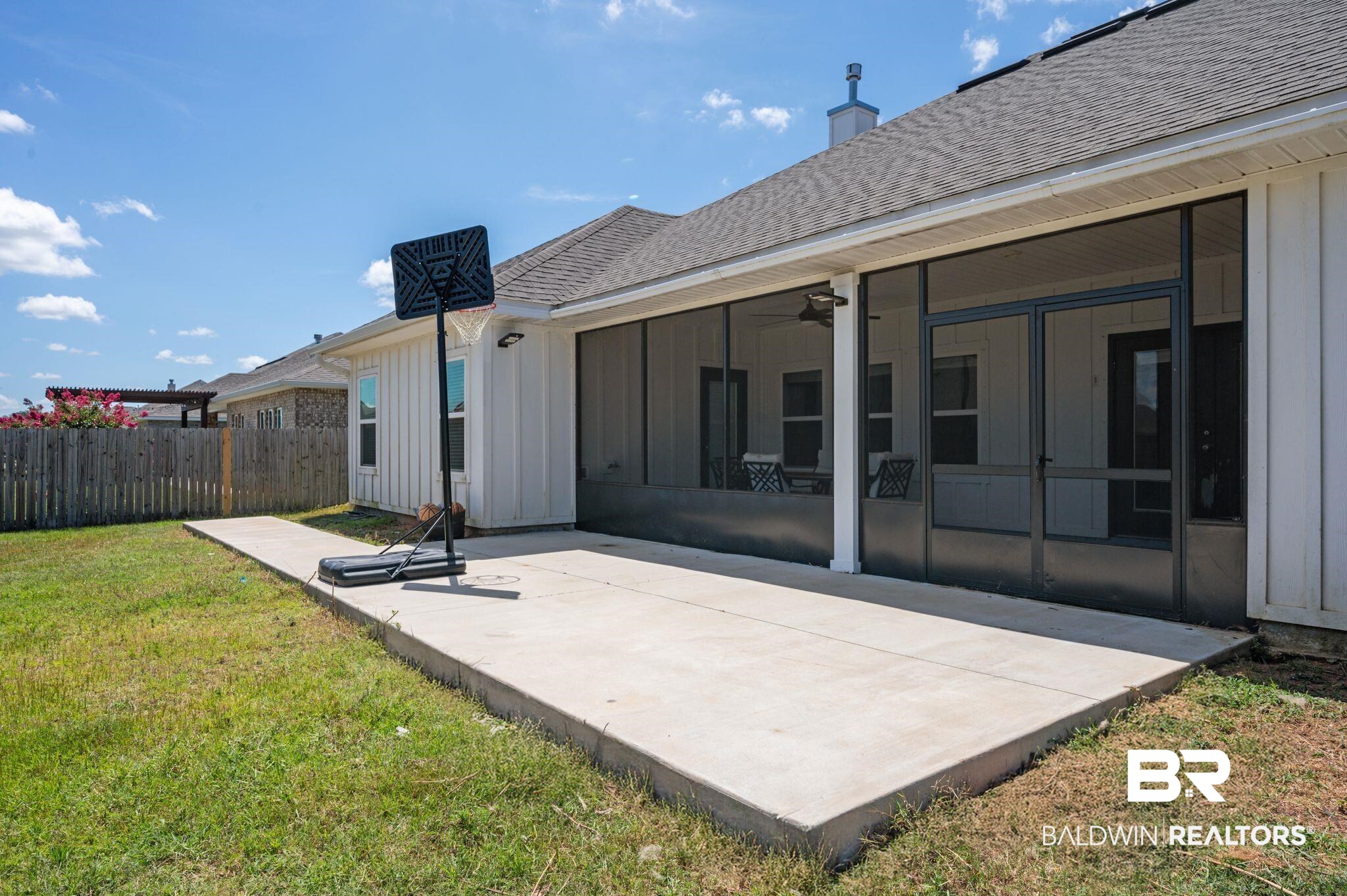 10169 Dunleith Loop Daphne, AL 36526 - Photo 12 of 40 Rear view of house with a sunroom, board and batten siding, a patio area, a shingled roof, and a chimney