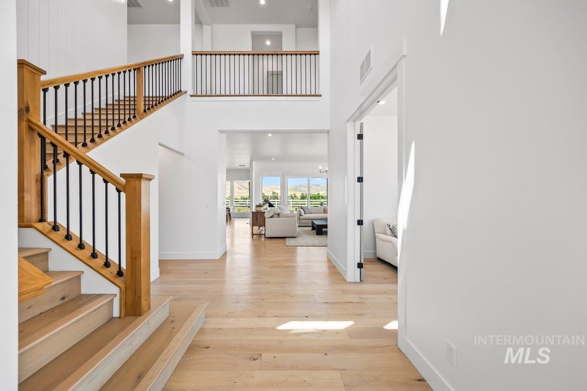 13746 North Ruffed Grouse Way Boise, ID 83714 - Photo 4 of 43 Entrance foyer featuring a towering ceiling, hardwood / wood-style floors, and stairs