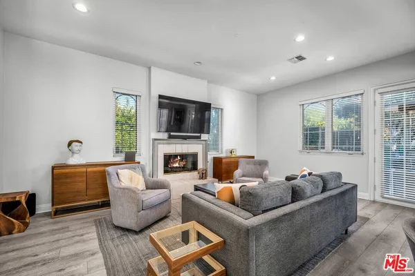 a living room with furniture a fireplace and a flat screen tv
