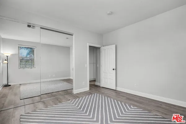 a view of a livingroom with wooden floor and a bathroom