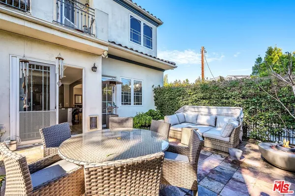 a view of a patio with couches table and chairs and potted plants
