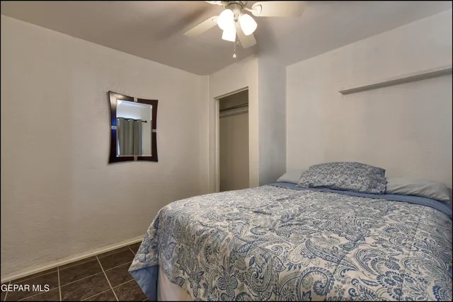 a view of a big room with windows and chandelier fan