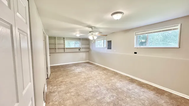 an empty room with windows and cabinet