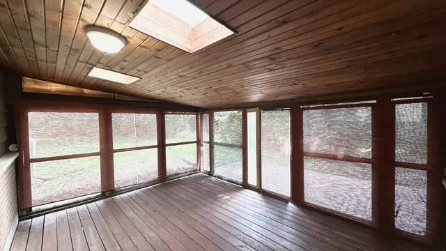 a view of empty room with floor to ceiling window and door