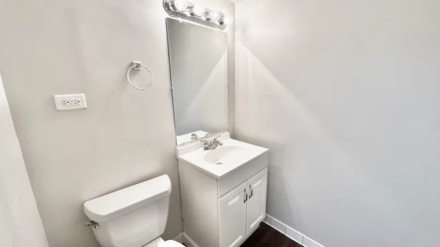 a bathroom with a sink toilet and mirror