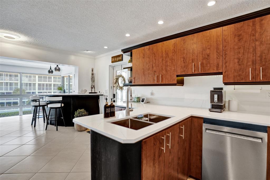3090 Northeast 48th Street, Unit 316 Fort Lauderdale, FL 33308 - Photo 13 of 49 a kitchen with a sink a table and chairs in it