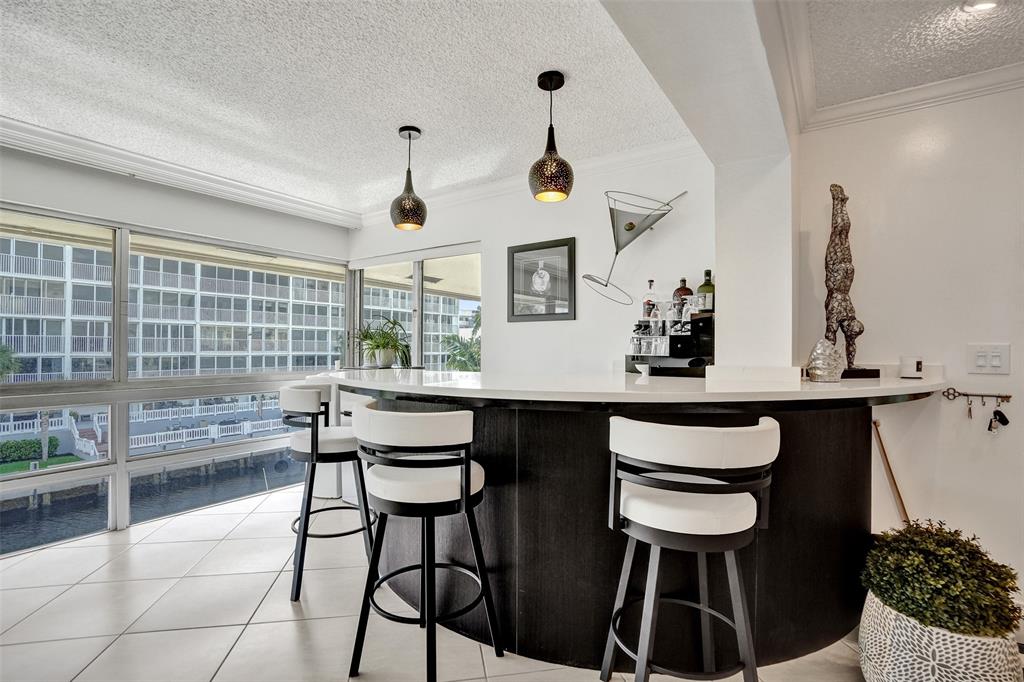 3090 Northeast 48th Street, Unit 316 Fort Lauderdale, FL 33308 - Photo 14 of 49 a kitchen with a dining table chairs and white appliances