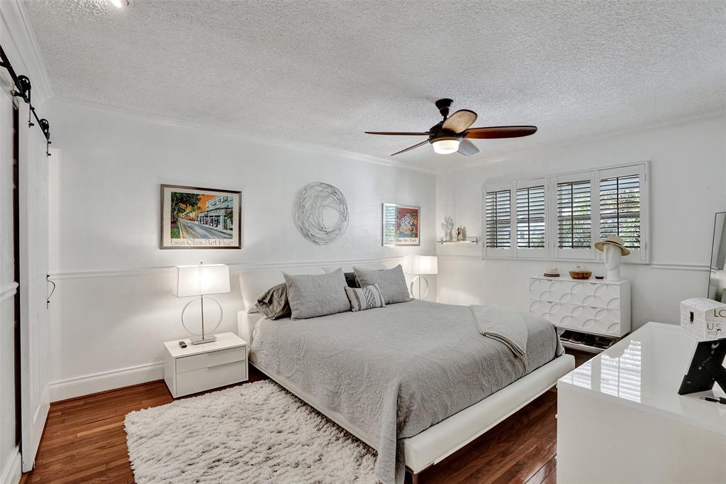 3090 Northeast 48th Street, Unit 316 Fort Lauderdale, FL 33308 - Photo 24 of 49 a bedroom with a bed and a chandelier