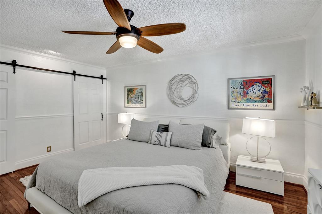 3090 Northeast 48th Street, Unit 316 Fort Lauderdale, FL 33308 - Photo 25 of 49 a bedroom with a large bed and a chandelier