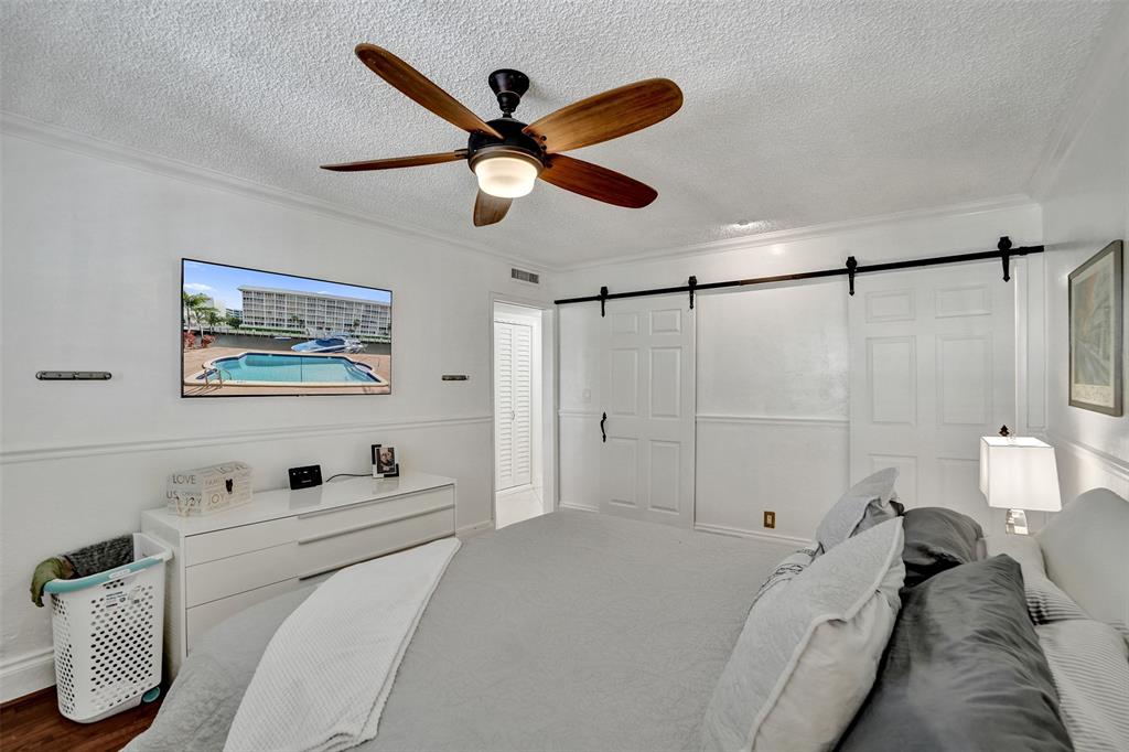 3090 Northeast 48th Street, Unit 316 Fort Lauderdale, FL 33308 - Photo 26 of 49 a bedroom with a bed and a painting on the wall