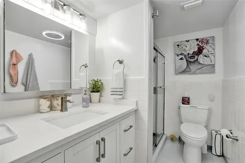 a bathroom with a granite countertop sink toilet and shower