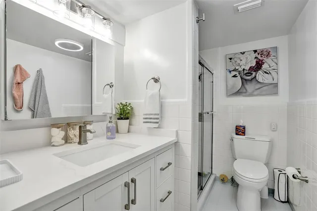a bathroom with a granite countertop sink toilet and shower