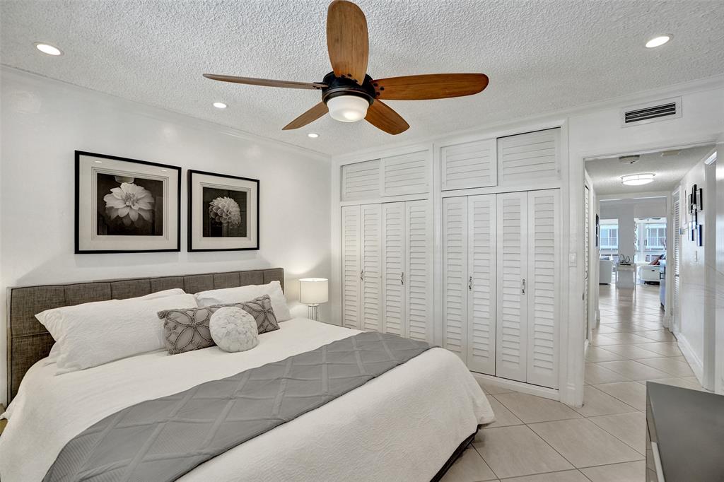 3090 Northeast 48th Street, Unit 316 Fort Lauderdale, FL 33308 - Photo 30 of 49 a bedroom with a bed and a chandelier