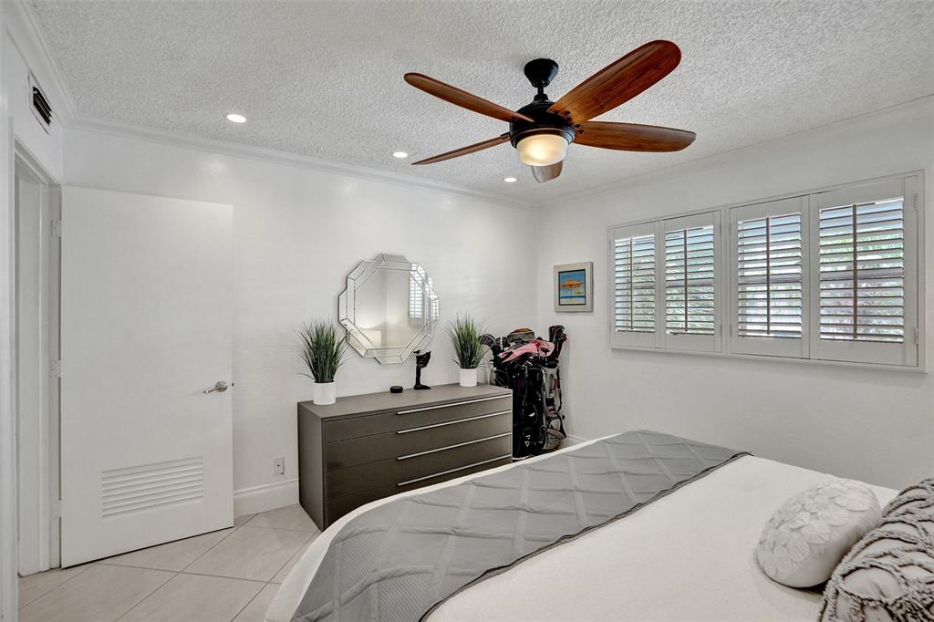 3090 Northeast 48th Street, Unit 316 Fort Lauderdale, FL 33308 - Photo 31 of 49 a bedroom with a bed and a chandelier