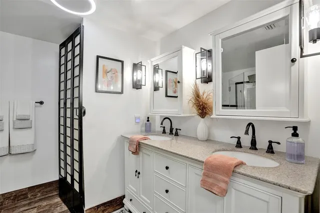 a bathroom with double vanity and a mirror