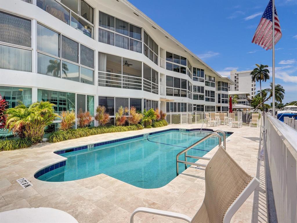 3090 Northeast 48th Street, Unit 316 Fort Lauderdale, FL 33308 - Photo 49 of 49 a view of a swimming pool with a lounge chairs