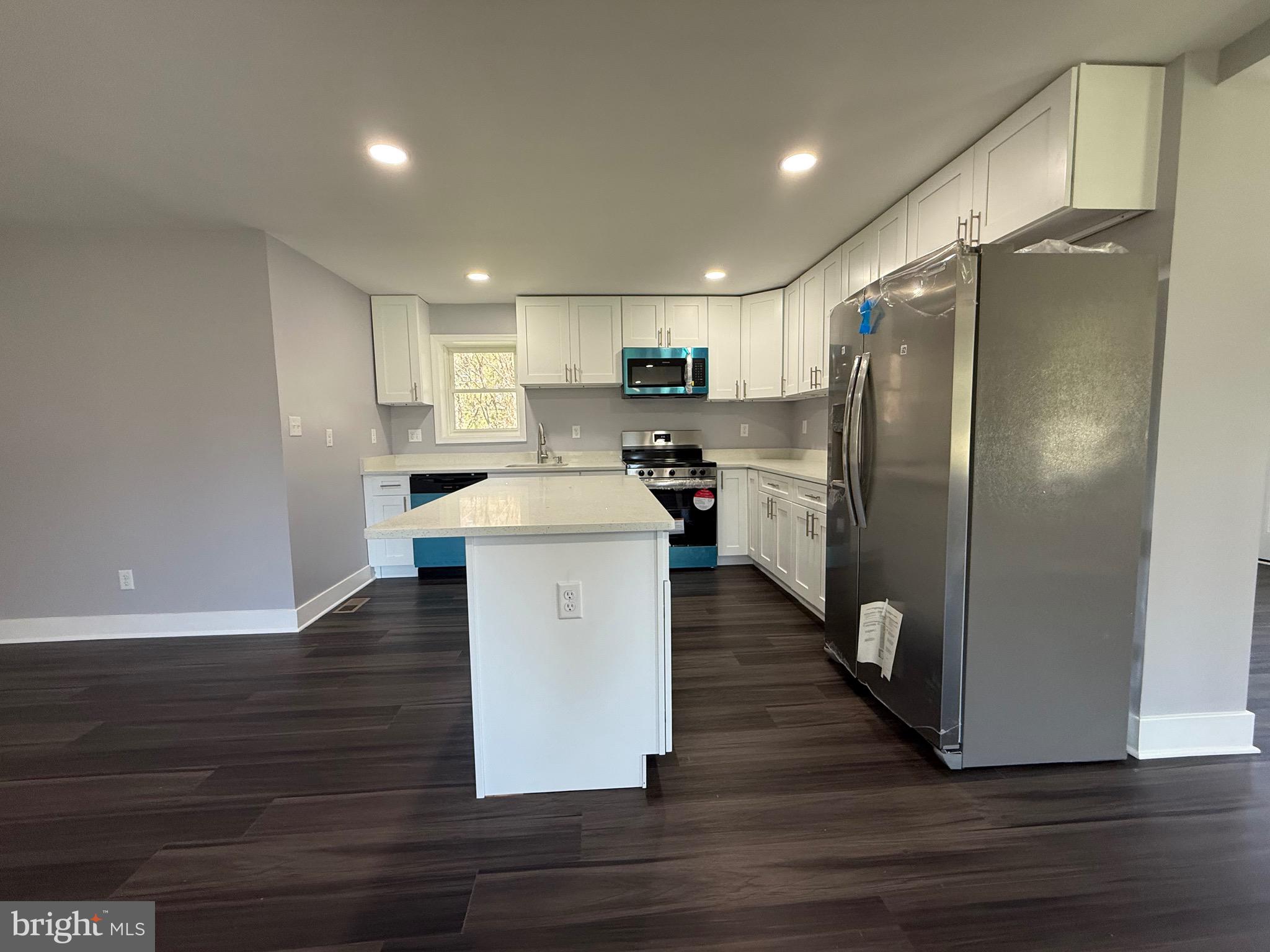 2600 Kingsway Road Fort Washington, MD 20744 - Photo 9 of 37 a kitchen with kitchen island white cabinets stainless steel appliances and wooden floor