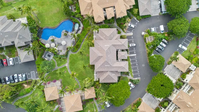 an aerial view of a residential house with yard and swimming pool