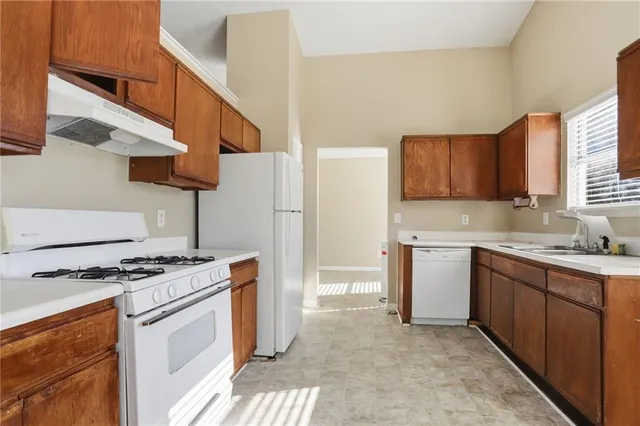 a kitchen with stainless steel appliances granite countertop a stove a sink and a refrigerator