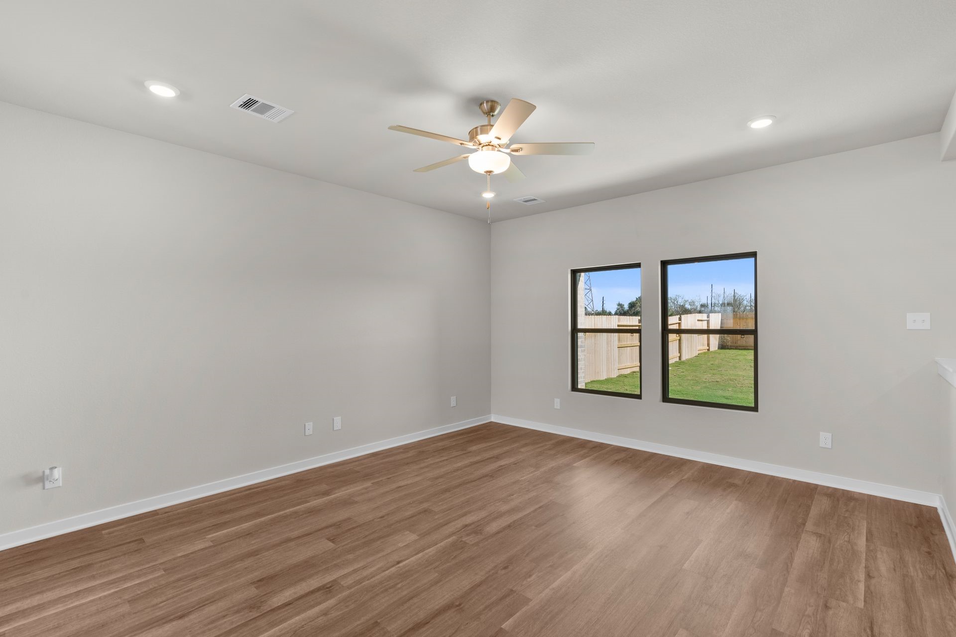 13319 Prado Rdg Lane Rosharon, TX 77583 - Photo 8 of 33 an empty room with wooden floor chandelier fan and windows