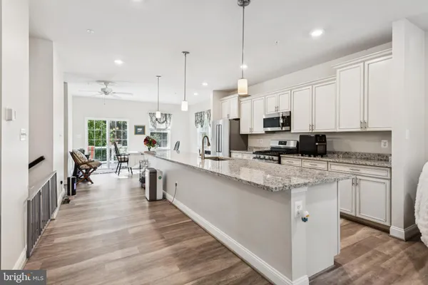 a large white kitchen with lots of counter space a sink appliances and a counter space