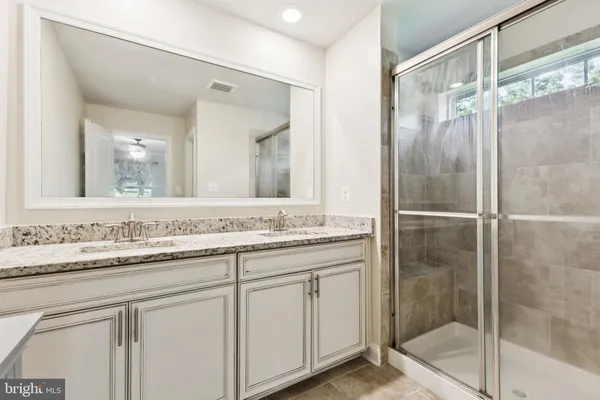 a bathroom with a shower sink and mirror