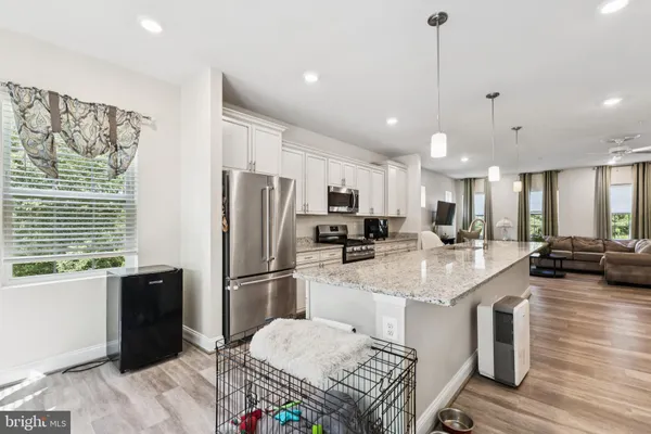 a kitchen with stainless steel appliances granite countertop a sink refrigerator and cabinets